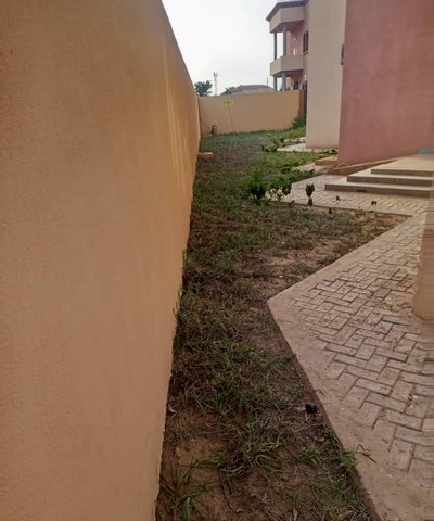 Allée pavée et pelouse nouvellement engazonnée le long du mur d'enceinte de l'ambassade de Mauritanie