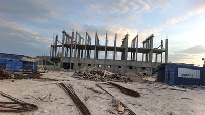Foyer des filles en construction, coffrage des poteaux et chaînage haut, conteneurs de chantier SOBAFOR au premier plan