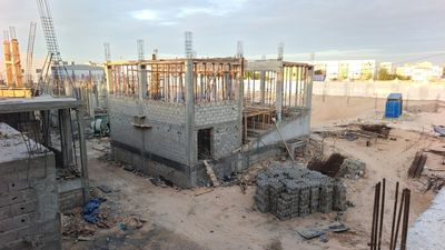 Bâtiment de l'amphithéâtre en construction, étaiement de l'étage et stock de hourdis au premier plan